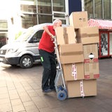 Ein Mann lädt Pakete auf eine Sackkarre.