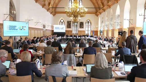 Politiker sitzen an einem Tisch bei der Verkehrsministerkonferenz