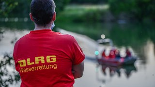 Einsatzkräfte der Feuerwehr, der Polizei, des Rettungsdienstes und der Deutsche Lebens-Rettungs-Gesellschaft (DLRG) suchen an einem See bei nach einer vermissten Person.