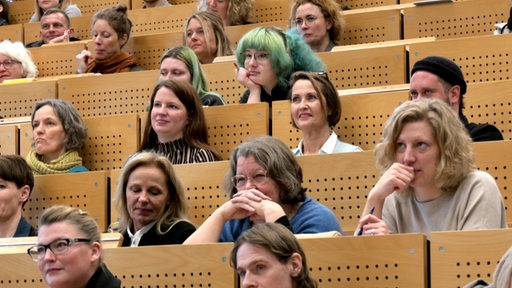 Viele Beteiligte des Kita-Gipfels sitzen in einer Art Vorlesungs-Saal und hören gespannt zu. 