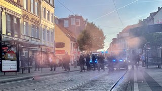 Menschen stehen auf einer Straße im Viertel.