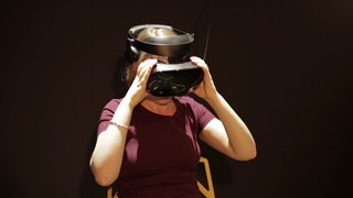 Eine Frau setzt sich eine Virtual Reality Brille aufs Gesicht.