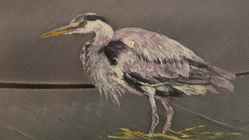Ein Reier gemalt auf einer Vogelfeder.