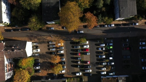 Aus der Vogeleperspektive ist ein Parkplatz mit vielen parkenden Autos zu sehen. 