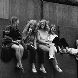 SW-Foto aus den 70er Jahren zeigt jugendliche Mädchen lachend an einem Denkmal sitzend.