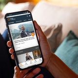 Eine junge Frau hält ein Smartphone mit der Buten un Binnen Website in den Händen
