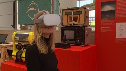 Eine Frau, die eine VR Brille trägt.