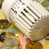 Ein Thermostat liegt auf Euro-Scheinen und -Münzen.