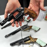 Ein Polizist hält eine Pistole in der Hand, die zuvor sichergestellt wurde.