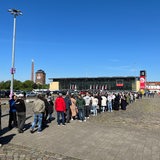 Eine Menschenschlange vor der Messehalle 7