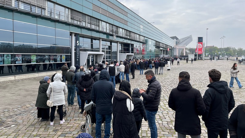Menschen warten am Eingang der Messehalle 4 auf Einlass zur Türkei-Wahl