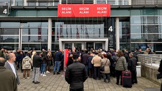 Menschen warten am Eingang der Messehalle 4 auf Einlass zur Türkei-Wahl