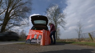 Wahlplakate werden in einen Kofferraum geräumt