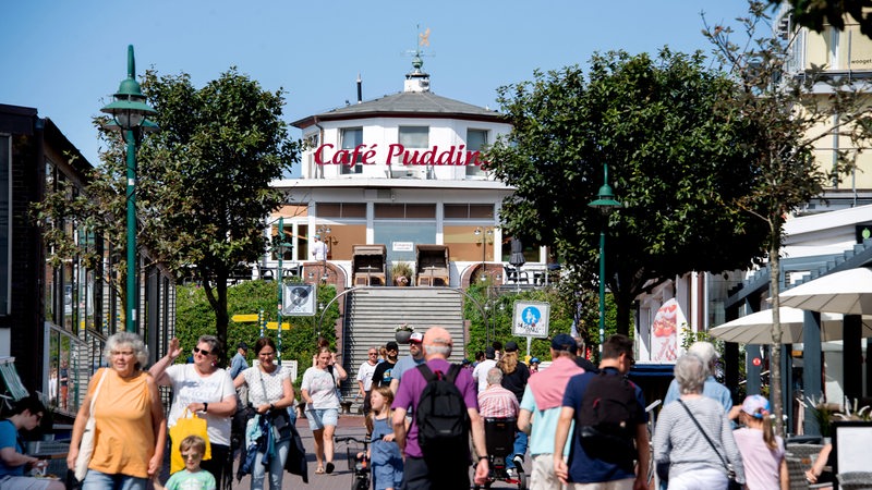 Zahlreiche Touristen gehen bei sonnigem Wetter durch die Zedeliusstraße im Ortskern der Insel Wangerooge.