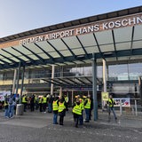 Am Bremer Flughafen wird gestreikt. Alle Flüge sind gestrichen. Vor dem Gebäude protestieren Mitarbeiter.
