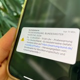 Ein Handydisplay zeigt eine Warnmeldung zum Warntag an.