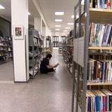 Ein junger Mann aus dem Iran sitzt in einer Bibliothek.