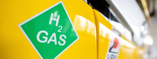 Ein Bus mit einem Wasserstoff-Antrieb hat auf seiner Front einen Aufkleber mit der Aufschrift "H2 Gas".