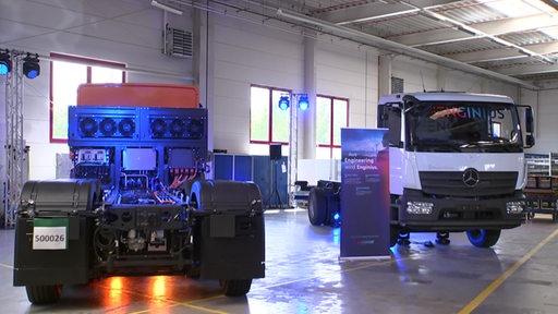 Zwei LKW's mit Wasserstoffantrieb stehen in einer Halle der Faun-Gruppe in Osterholz.