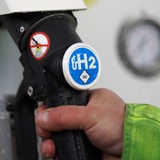 Der Tankhahn mit der Aufschrift "H2" ist an einer Tanksäule einer Wasserstoff-Tankstelle zu sehen.
