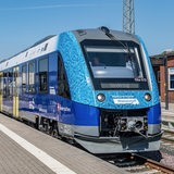 Ein blauer Zug steht an einem leeren Bahnsteig.