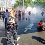 Ein Wasserwerfer spritzt auf Demonstranten