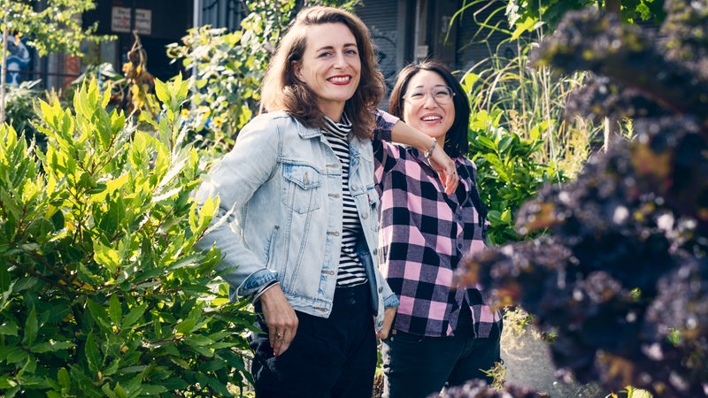 Jessica Liedtke und Shia Su stehen bei Sonnenschein in einem Garten