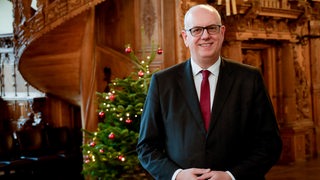 Der Bremer Bürgermeister steht im weihnachtlichen Rathaus.
