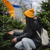 Eine Frau beim Kauf eines Weihnachtsbaumes