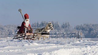 Nikolaus mit Pferd und Schlitten in Schneelandschaft