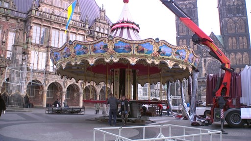 Auf dem Bremer Marktplatz wird das Karussel für den Weihnachtsmarkt aufgebaut.
