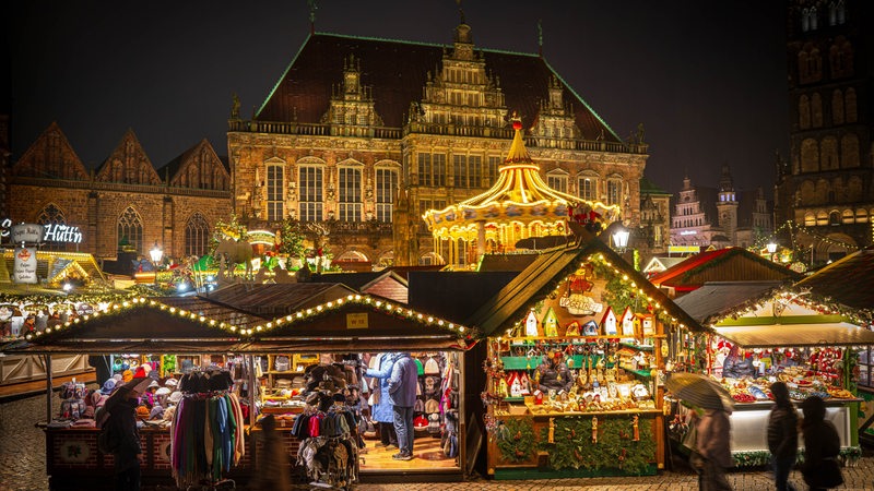 Buden des Weihnachtsmarkts stehen hell erleuchtet auf dem Bremer Marktplatz.