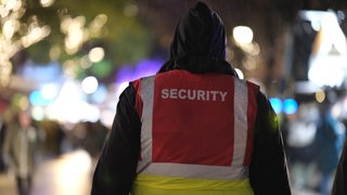 Ein Security-Mitarbeiter geht über den Weihnachtsmarkt Schlachtezauber in Bremen