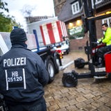 Einsatzkräfte der Polizei stellen Poller zum Schutz des Weihnachtsmarktes auf.