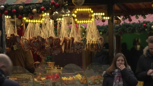 Ein  Stand auf dem Weihnachtsmarkt mit Lebkuchenherzen und Mandeln. 
