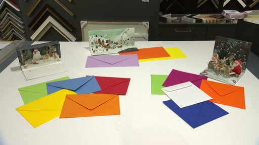 Mehrere Weihnachtskarten mit Briefumschlägen auf einem Tisch.