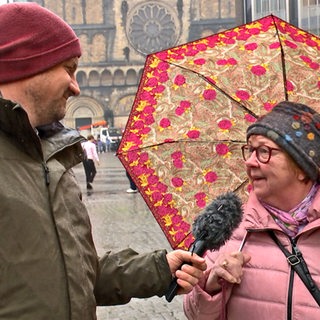 Reporter Heyko Habben interviewt eine ältere Dame auf dem Bremer Marktplatz.