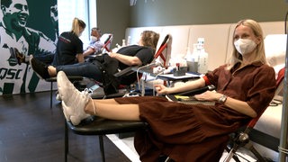 Eine Frau liegt auf einer Liege und spendet Blut.