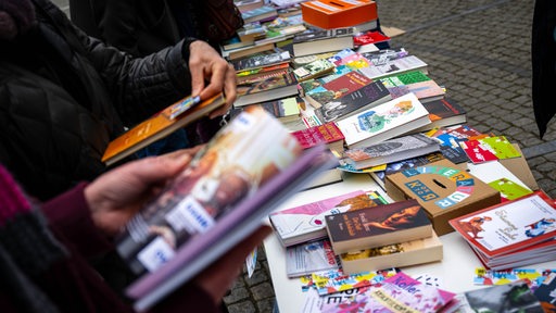 Auf einem Tisch liegen zahlreiche Bücher aus.
