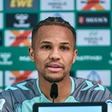 Felix Agu sitzt auf dem Podium und beantwortet Fragen.