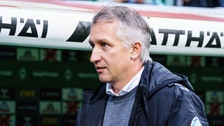 Frank Baumann steht vor der Trainerbank im Weser-Stadion.