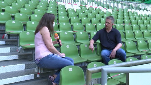 Frank Baumann sitzt mit Pascale Ciesla währen des Interviews auf der Tribüne des Weser-Stadions.