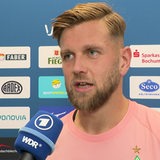 Werder-Torschütze Niclas Füllkrug steht nach dem Spiel in Bochum vor einer Werbewand beim Interview.
