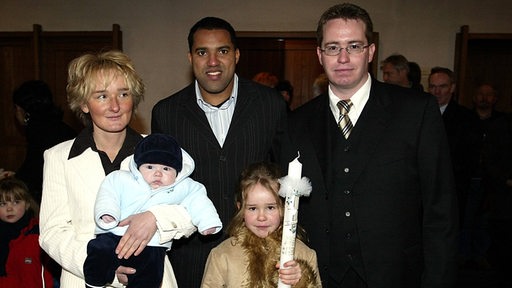 Ailton und die Familie Diegmann posieren für ein Foto nach der Taufe von Niklas Ailton.