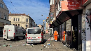 Ein Mitarbeiter der Straßenreinigung sammelt Müll ein