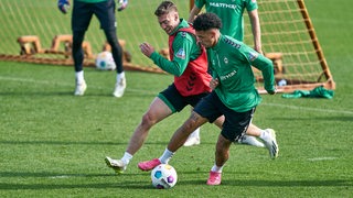 Werder-Stürmer Justin Njinmah und Mitchell Weiser kämpfen im Training um den Ball.