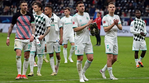 Mehrere Werder-Spieler applaudieren ihren Fans nach dem 1:1-Remis bei Eintracht Frankfurt.