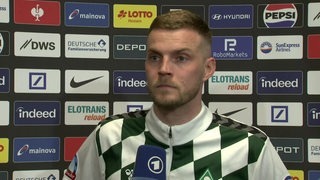 Werder-Angreifer Marvin Ducksch blickt während eines ARD-Interviews an der Kamera vorbei.
