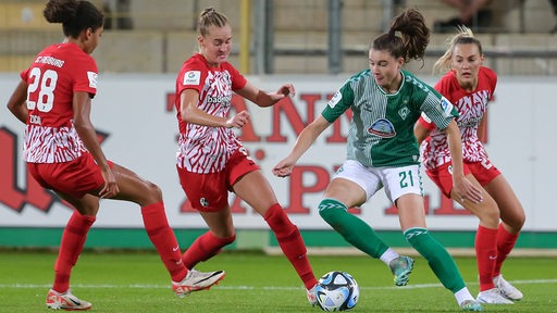 Werder-Sielerin Chiara Hahn setzt sich gegen drei Freiburger Gegenspielerinnen durch.