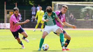 Werder-Spieler Jakob Löpping schirmt den Ball gegen seinen Gegenspieler ab.